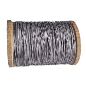 May include: A spool of grey thread wound tightly around a cylindrical wooden core. The thread features a smooth, consistent texture and a metallic sheen, covering the entire length of the spool between the two circular wooden end caps.
