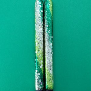 May include: Two green and silver glitter pens with black caps.