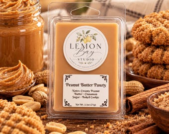 Könnte beinhalten: Ein rechteckiges, hellbraunes Duftwachs in einer durchsichtigen Kunststoffverpackung. Das Etikett zeigt den Text Lemon Bay Studio und Peanut Butter Pawty mit Noten von Erdnussbutter, Zimt, Zucker und gebackenem Keks, Nettogewicht 71g.