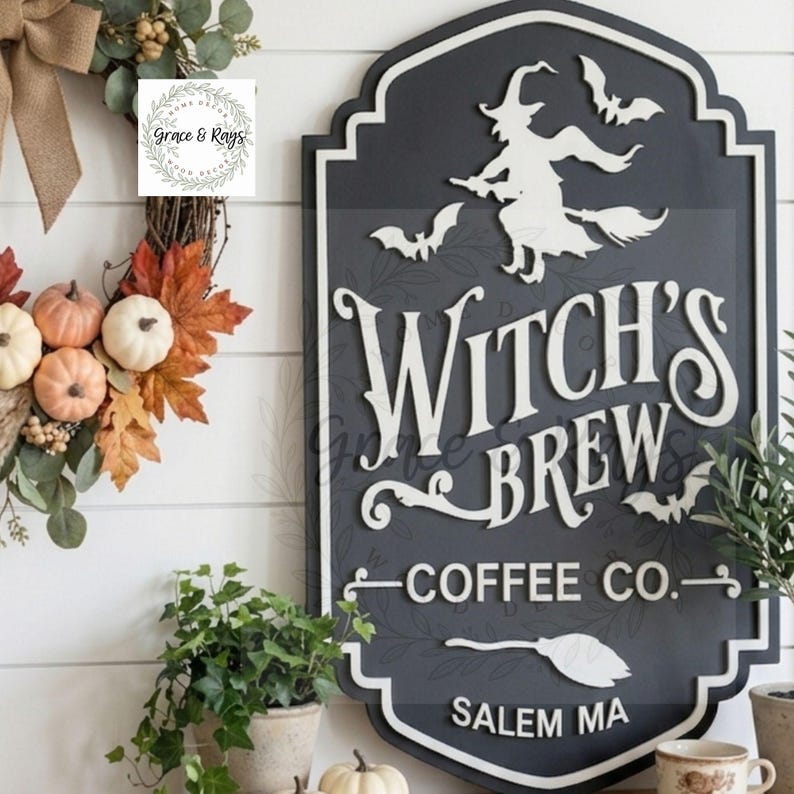 May include: A dark gray, shield-shaped wooden sign with white raised lettering that reads Witch's Brew Coffee Co. Salem MA. The sign features a white silhouette of a witch on a broomstick, three bats, and a broom icon, all with a white border.