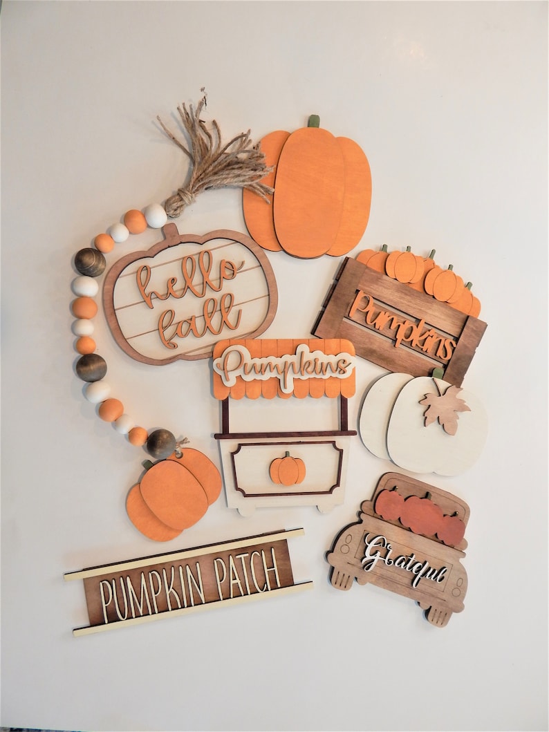 May include: A set of wooden autumn decorations featuring pumpkins, a truck, and signs that say "hello fall", "pumpkins", "pumpkin patch", and "grateful".