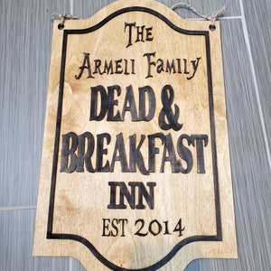 May include: A wooden sign with black lettering that reads "The Armeii Family Dead & Breakfast Inn Est 2014".