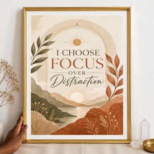 Op de afbeelding: Een ingelijste wandkunstprint met een landschap van bergen, een meer en een zon. De tekst luidt I CHOOSE FOCUS OVER DISTRACTION. Het kleurenpalet bevat tinten terracotta, beige, olijfgroen en crème met botanische elementen.