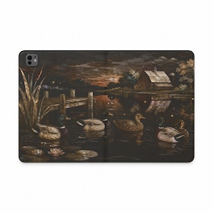Peut inclure: Un étui pour tablette rectangulaire illustrant un paysage sombre et atmosphérique avec quatre canards colverts nageant sur un lac calme au crépuscule. La scène comprend un ponton en bois, des roseaux, des nénuphars et une grange rustique.