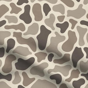 May include: A fabric pattern featuring an irregular, organic camouflage-style print in shades of cream, light taupe, and dark brown. The design consists of rounded, amoeba-like shapes that interlock across the surface, creating a continuous, repeating motif with a soft, woven texture visible throughout the material.
