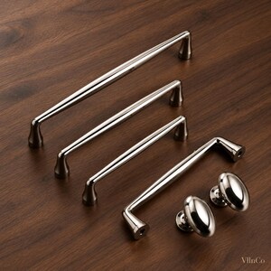May include: A collection of polished nickel cabinet hardware including four varying lengths of arched drawer pulls and two matching oval-shaped cabinet knobs. Each piece features a smooth, reflective metallic finish and a sturdy base.