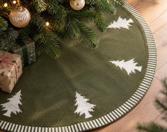 Könnte beinhalten: Ein runder, olivgrüner Strick-Weihnachtsbaumteppich mit einem sich wiederholenden weißen Tannenbaummuster und einem gestreiften weiß-olivgrünen Rand. Das Textil weist eine strukturierte Strickoptik mit einer einheitlichen Farbgebung auf.