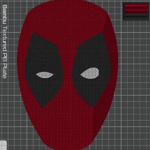 May include: A digital design of a red mask with large black eye patches and white eye lenses, displayed on a gray grid background. The text Bambu Textured PEI Plate is visible on the left side, and a small red and black rectangular icon is in the top right corner.