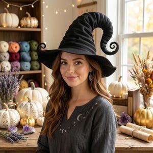 May include: A black witch hat with a tall, curved, and pleated crown featuring a wide brim with curled edges. The hat is constructed from a dark fabric with a textured, ribbed appearance, designed with a distinct pointed top that bends downward.