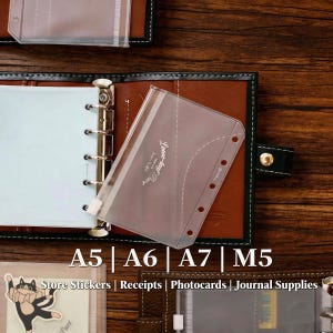 May include: A brown leather binder with a six-ring metal mechanism and a translucent plastic zipper pouch. The pouch features the text Loose-leaf Page. The image includes the text A5 | A6 | A7 | M5 and Store Stickers | Receipts | Photocards | Journal Supplies.