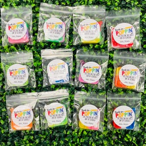 Puede incluir: Doce peque&ntilde;as bolsas de pl&aacute;stico transparentes que contienen cada una un juguete pop-it cuadrado de colores y una pegatina redonda que dice "&iexcl;Gracias por venir! &iexcl;Nos vemos el primer d&iacute;a de escuela! -Sra. Raza"