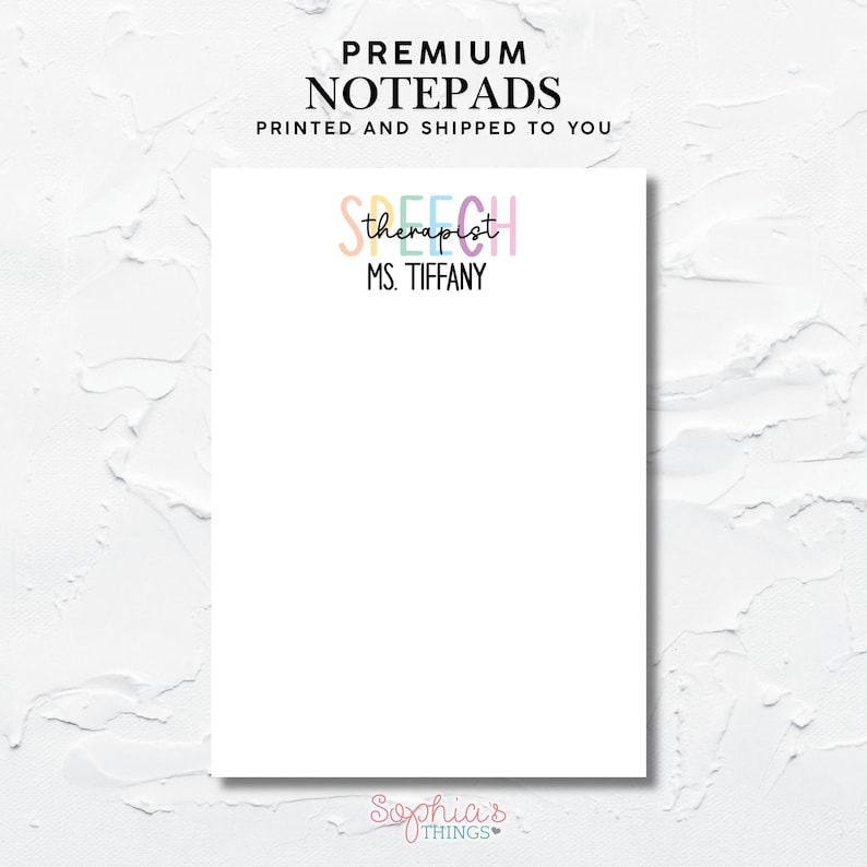Op de afbeelding: Een witte notitieblok met bovenaan de tekst "PREMIUM NOTEPADS". Daaronder staat "SPEECH therapist" in pastelkleuren, gevolgd door "MS. TIFFANY" in zwart. De onderkant van het notitieblok heeft de tekst "Sophia's THINGS".