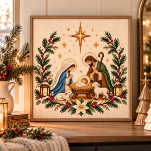 Peut inclure: Une broderie au point de croix encadrée représentant une scène de nativité avec une crèche centrale, des personnages et des animaux, entourée d'une couronne festive de branches de pin vert, de baies rouges et d'un poinsettia blanc.