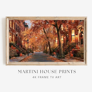 May include: A framed digital art print depicting a city street lined with brick townhouses during autumn. The scene features orange and yellow foliage, glowing street lamps, a yellow taxi in the distance, and pumpkins on the front steps.