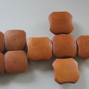 May include: Eight wooden coasters in various shapes and sizes. The coasters are all a light brown color and have a smooth, polished finish.