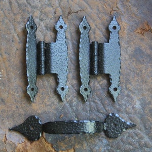 May include: Three black metal hinges with decorative pointed ends and a black metal handle with pointed ends.