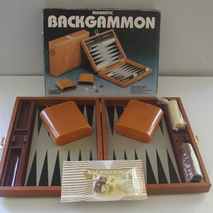 May include: A vintage magnetic backgammon set with a brown wooden board and orange plastic pieces. The box reads "MAGNETIC BACKGAMMON" in bold letters. Includes dice and game pieces. A classic board game.