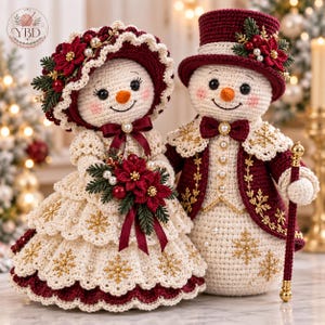 Op de afbeelding: Twee gehaakte sneeuwpopfiguren in formele kleding. Het vrouwelijke figuur draagt een crèmekleurige jurk met gouden sneeuwvlokborduursels, een bijpassende muts en een boeket kerststerren. Het mannelijke figuur draagt een bordeauxrode hoge hoed.
