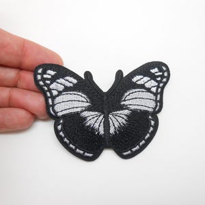 Può includere: Toppa a farfalla ricamata in bianco e nero. La farfalla presenta motivi alari dettagliati con accenti bianchi su sfondo nero. Questa toppa decorativa può essere cucita o stirata sugli indumenti.