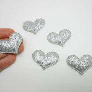 Könnte beinhalten: Fünf silberne Glitzer-Herz-Verzierungen. Die Herzen sind etwa 2,5 cm groß.