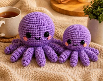 May include: Two purple crochet octopus plushies with round heads, eight curled tentacles each, black plastic eyes, and small pink stitched cheeks. The larger octopus is positioned to the left of the smaller one, both featuring a textured yarn finish.