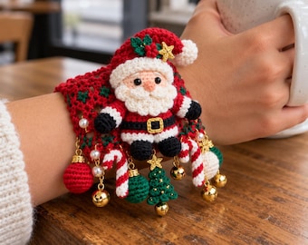 May include: A red and green crocheted wrist cuff featuring a central Santa Claus figure, accented with dangling charms including miniature candy canes, gold bells, a green Christmas tree, a red ball, and small white pearls.