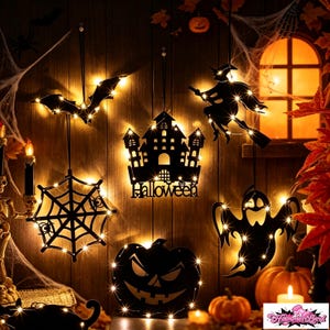 May include: A collection of black hanging Halloween decorations featuring a bat, a spider web, a haunted house with the text Halloween, a witch on a broomstick, a ghost, and a jack-o'-lantern, all illuminated by warm white LED string lights.