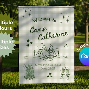 Op de afbeelding: Een rechthoekige banner met een lichtgroen en wit ruitpatroon met donkergroene tekst die Welcome to Camp Catherine, EST. 2026, Silver Pine Lake, NZ, June 26-28 leest, naast illustraties van bergen, een kampvuur en glazen champagne.