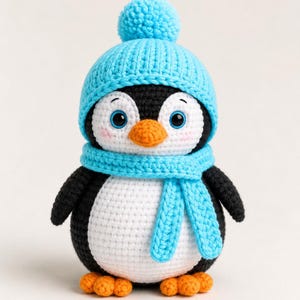 May include: A crocheted penguin toy featuring a black and white body, an orange beak, and orange feet. The penguin wears a bright light blue crocheted beanie with a matching pom-pom on top and a coordinating light blue scarf wrapped around its neck.