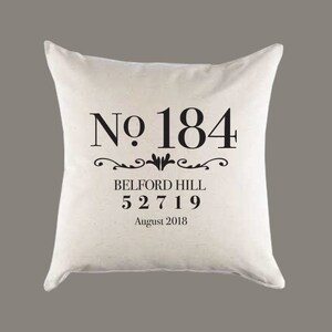 Op de afbeelding: Wit kussen met zwarte tekst die "No. 184", "Belford Hill", "52719" en "August 2018" zegt.