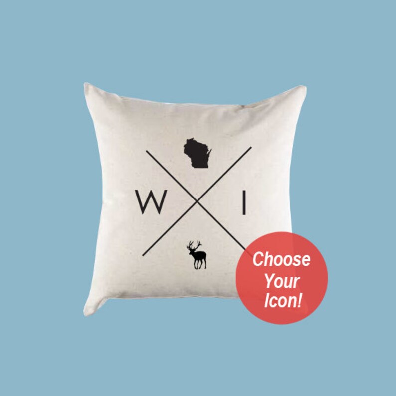 Puede incluir: Una almohada blanca con un dise&ntilde;o en blanco y negro que presenta el estado de Wisconsin, las letras "WI" y la silueta de un ciervo. El texto "&iexcl;Elige tu icono!" est&aacute; en un c&iacute;rculo rojo.