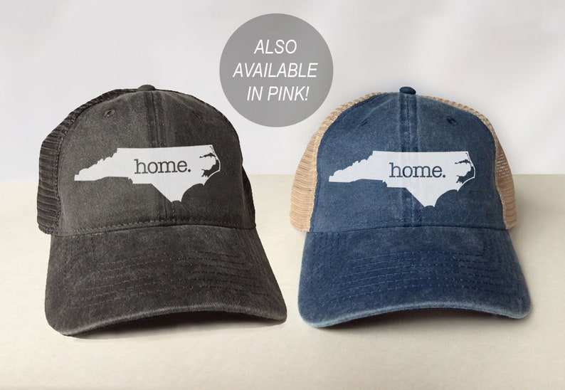 May include: Two trucker hats with a mesh back. The hats are black and blue with a white outline of the state of North Carolina and the word "home." printed on the front.