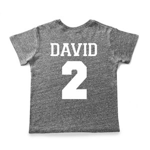 Pu&ograve; includere: Una maglietta grigia melange con il nome "DAVID" e il numero "2" stampati in bianco sul retro.