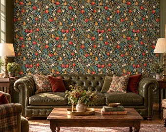 Puede incluir: Un sofá de cuero capitoné verde oscuro se sitúa frente a una pared con papel pintado de un denso patrón de manzanas rojas, peras amarillas, flores blancas y hojas verdes. Una mesa de centro de madera sostiene un arreglo floral y libros.