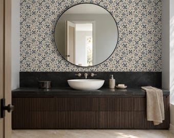 Puede incluir: Un mueble de baño con armario de listones marrón oscuro, encimera de piedra negra y lavabo blanco. Sobre el lavabo hay un espejo redondo y papel pintado con un patrón floral geométrico repetitivo en azul, beige y negro.