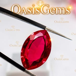Puede incluir: Una piedra preciosa de color rojo vibrante con corte marquesa sostenida por pinzas de metal negro. La piedra presenta una superficie facetada que refleja la luz. El texto OasisGems es visible al fondo y arriba, junto a un icono de diamante.