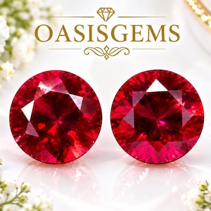 Könnte beinhalten: Zwei runde, facettierte, tiefrote Rubine sind nebeneinander abgebildet. Über den Edelsteinen ist der Text OASISGEMS in Gold gedruckt, begleitet von einem kleinen Diamantsymbol und dekorativen Linien. Die Steine sind von weißen und rosa Blumen umgeben.