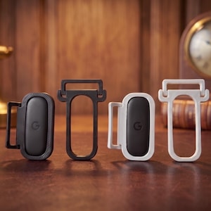 May include: Two black and two white plastic clips, each featuring a central black oval insert with a small letter G embossed in the center. The clips have a rectangular frame design with a hinged top bar, presented in a set of four individual units.