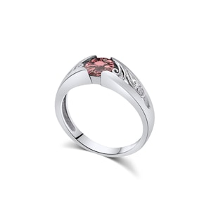 Op de afbeelding: Een zilverkleurige ring met een ronde, gefacetteerde, oudroze edelsteen in een spanning-stijl zetting. De band is voorzien van ingewikkelde, verhoogde krulpatronen aan de zijkanten, die naar de centrale steenzetting toe leiden.