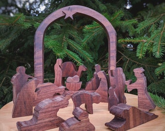 May include: A wooden nativity scene with a star on top of the archway. The figures are made of dark wood and include Mary, Joseph, baby Jesus, a donkey, a camel, and three wise men.