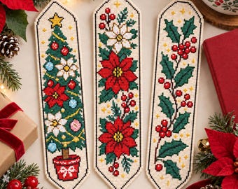Può includere: Tre segnalibri a punto croce su tessuto color crema. Quello a sinistra mostra un albero di Natale decorato in un vaso rosso. Al centro sono raffigurate stelle di Natale rosse e bianche. A destra un rametto di agrifoglio verde con bacche rosse.