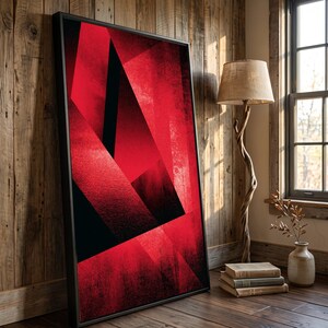 May include: A large rectangular framed wall art piece featuring a bold abstract composition of sharp, intersecting geometric shapes in vibrant shades of red and deep black, with a textured, layered appearance throughout the printed surface.