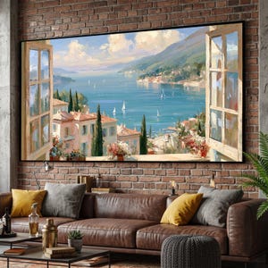 Könnte beinhalten: Ein rechteckiger Wandkunstdruck, der den Blick durch ein offenes Fenster auf eine Küstenstadt mit hellen Gebäuden, hohen Zypressen und Segelbooten auf einem blauen Meer unter einem bewölkten Himmel zeigt, eingerahmt von hölzernen Fensterrahmen.