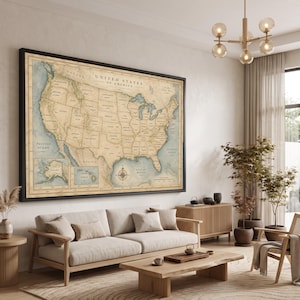 Pode incluir: Uma grande peça de arte de parede retangular com um mapa dos Estados Unidos da América em estilo vintage. O mapa exibe fronteiras estaduais, grandes cidades e características geográficas em tons de bege e azul, com uma moldura preta fina.