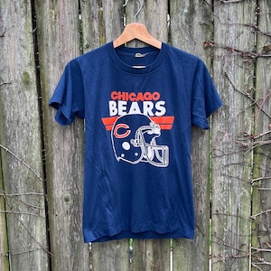 May include: A navy blue t-shirt with a white graphic of a football helmet and the text "CHICAGO BEARS" in red and white.