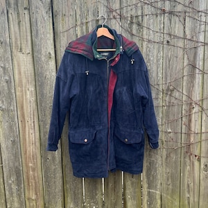 May include: A navy blue corduroy jacket with a red and green plaid lining. The jacket has a hood and two large pockets.