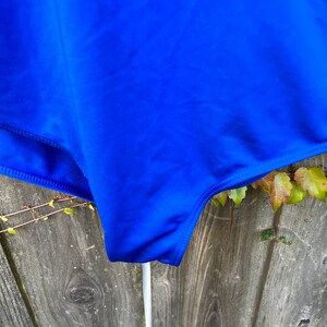 Pu&ograve; includere: Un costume da bagno blu brillante con un design semplice. Il costume da bagno &egrave; realizzato in un tessuto liscio ed elastico.