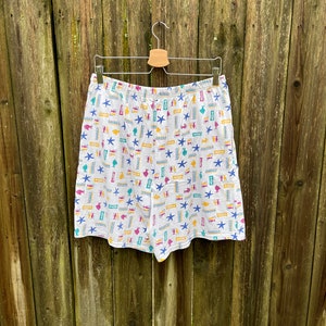 May include: White cotton shorts with a colourful pattern of fish, seashells, and starfish.