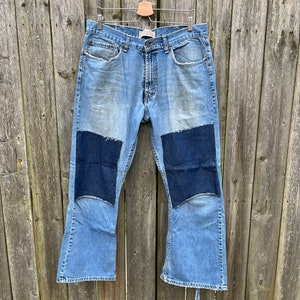 May include: A pair of blue denim bell bottom jeans with dark blue denim patches on the knees.