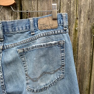 May include: A pair of light blue denim jeans with a back pocket and a brown leather patch that says "Wrangler Jeans Co."